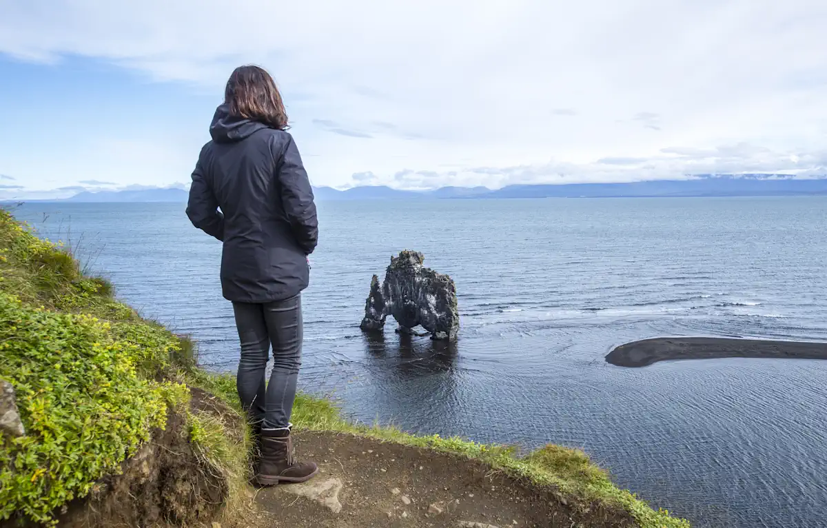 Une femme debout face à la mer