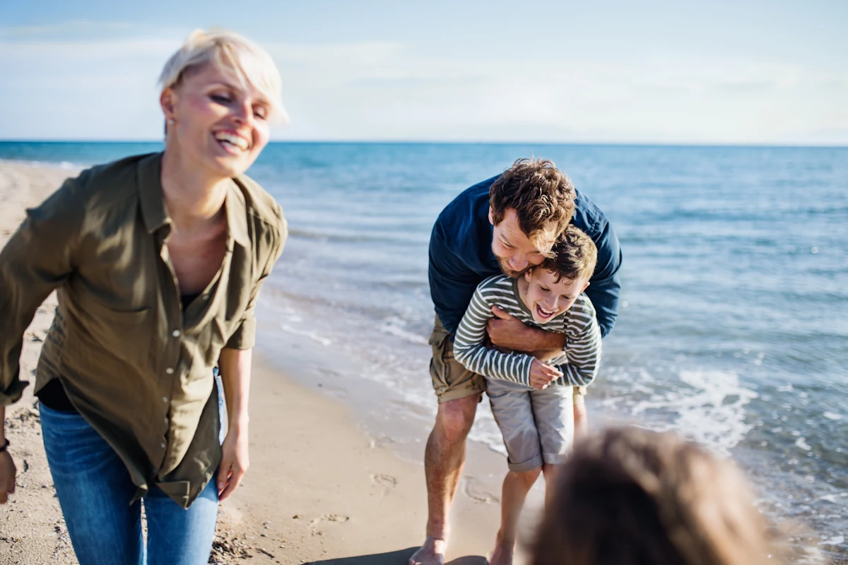 Une femme, un homme et des enfants qui s'amusent à la plage