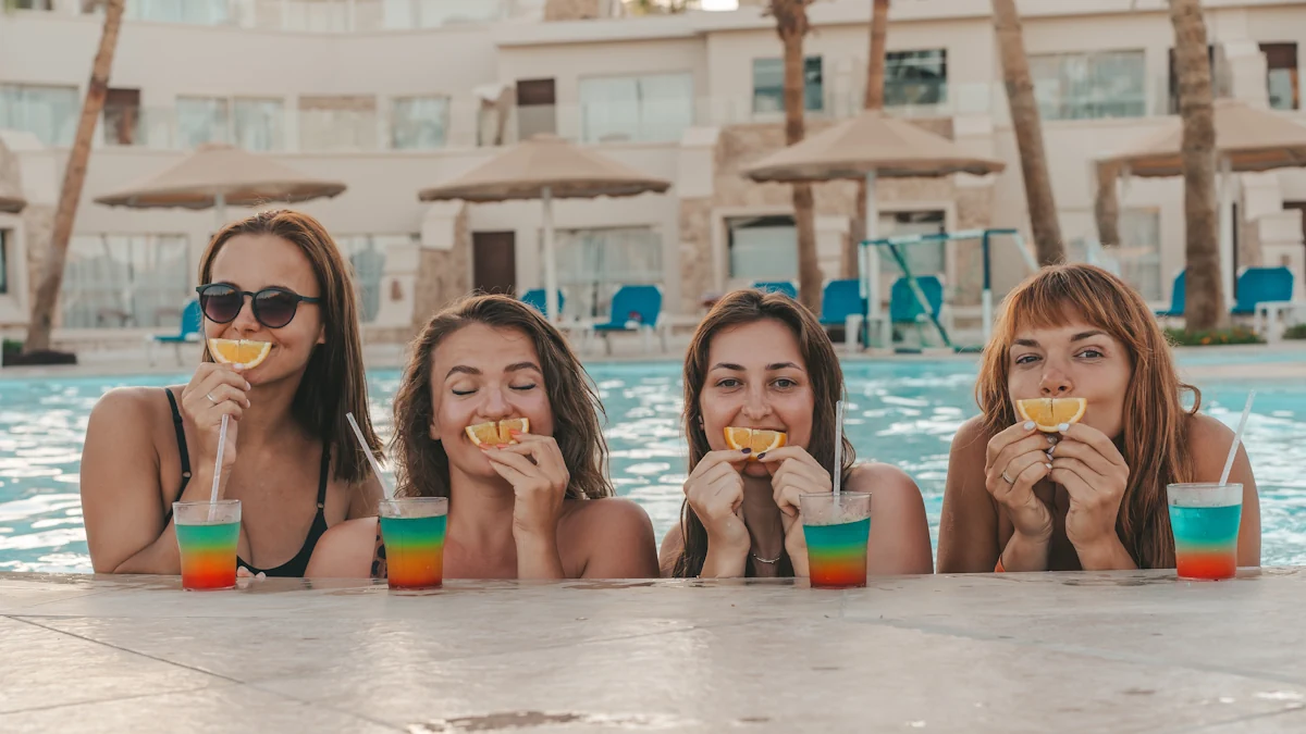 4 filles dans la piscine qui boit des cocktails